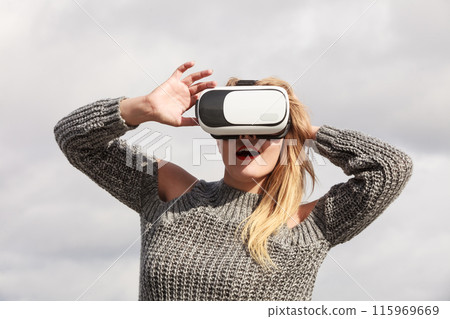 Woman wearing VR outside Woman wearing VR outside 115969669