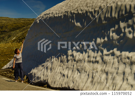 Tourist looking at high snow wall at road, Norway Tourist looking at high snow wall at road, Norway 115970052