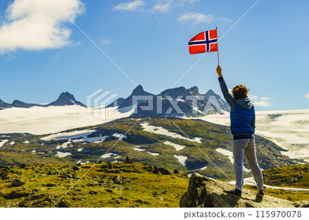 Tourist with norwegian flag in mountains 115970078