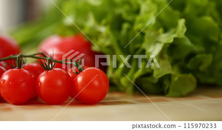 Cherry tomatoes lie on a cutting board 115970233