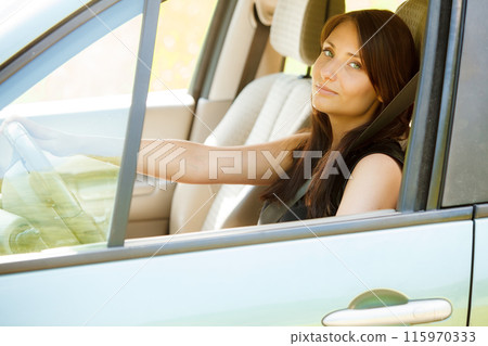 Woman driver hands holding steering wheel of a car 115970333