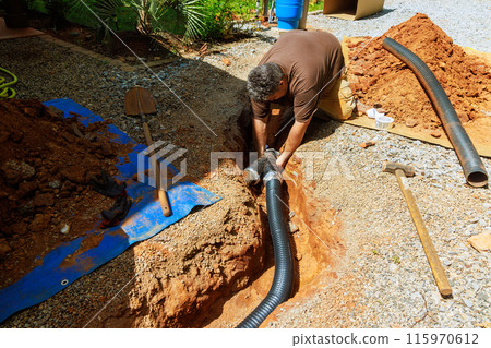 Assembling perforated flexible drain pipes for draining rainwater at trench Assembling perforated flexible drain pipes for draining rainwater at trench 115970612