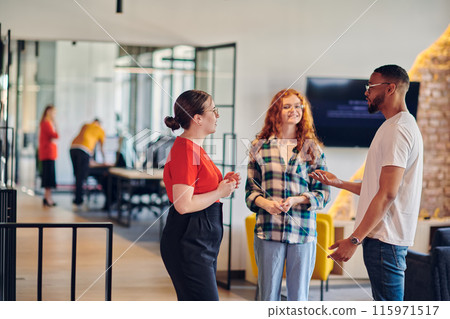 Group of business colleagues, including an African American businessman, engage in a conversation about business issues in the hallway of a modern startup coworking center, exemplifying dynamic 115971517