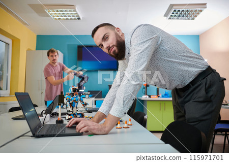 A group of colleagues working together in a robotics laboratory, focusing on the intricate fields of robotics and 3D printing. Showcase their dedication to innovation, as they engage in research 115971701