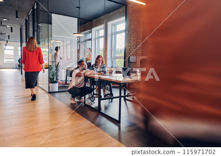 A diverse group of business professionals collaborates in a modern startup coworking center, utilizing a mix of paper-based and technological tools such as mobile phones and computers to collectively 115971702