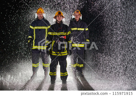 A group of professional firefighters marching through the rainy night on a rescue mission, their determined strides and fearless expressions reflecting their unwavering bravery and unwavering 115971915