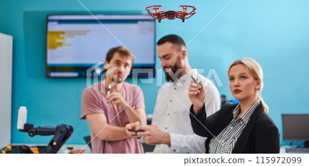 A group of students working together in a laboratory, dedicated to exploring the aerodynamic capabilities of a drone A group of students working together in a laboratory, dedicated to exploring the aerodynamic capabilities of a drone 115972099