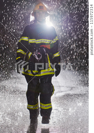 A determined female firefighter in a professional uniform striding through the dangerous, rainy night on a daring rescue mission, showcasing her unwavering bravery and commitment to saving lives. A determined female firefighter in a professional uniform striding through the dangerous, rainy night on a daring rescue mission, showcasing her unwavering bravery and commitment to saving lives. 115972314