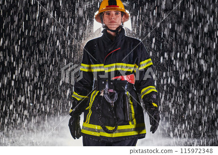 A determined female firefighter in a professional uniform striding through the dangerous, rainy night on a daring rescue mission, showcasing her unwavering bravery and commitment to saving lives. 115972348