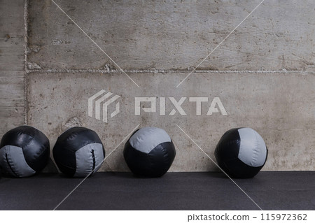 An empty modern gymnasium with a variety of equipment, offering a spacious, functional, and well-equipped training facility for workouts, fitness, and strength training 115972362