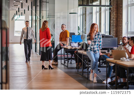 A diverse group of young business individuals congregates in a modern startup coworking center, embodying collaborative innovation and a dynamic atmosphere. 115972375
