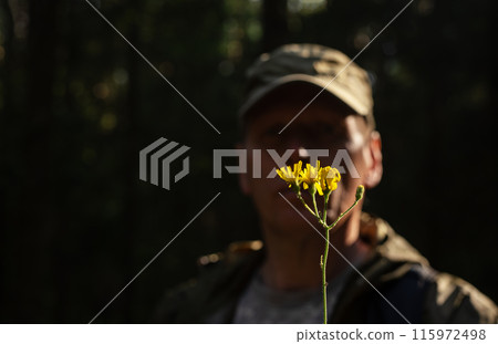 Male smelling flowers in nature, enjoying the psychology of the moment Woodland zen Peaceful, Male smelling flowers in nature, enjoying the psychology of the moment Woodland zen Peaceful, 115972498