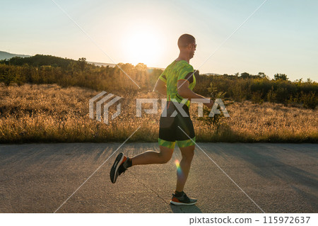 Triathlete in professional gear running early in the morning, preparing for a marathon, dedication to sport and readiness to take on the challenges of a marathon.  115972637