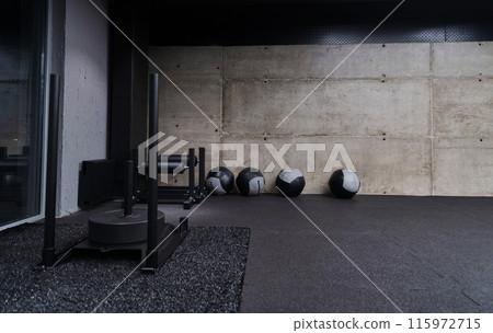 An empty modern gymnasium with a variety of equipment, offering a spacious, functional, and well-equipped training facility for workouts, fitness, and strength training 115972715