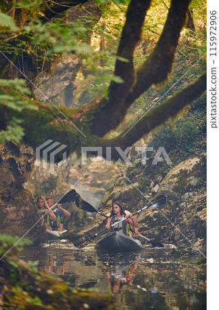 A group of friends enjoying having fun and kayaking while exploring the calm river, surrounding forest and large natural river canyons 115972906