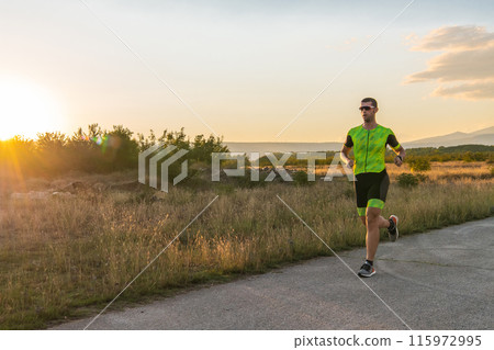 Triathlete in professional gear running early in the morning, preparing for a marathon, dedication to sport and readiness to take on the challenges of a marathon. Triathlete in professional gear running early in the morning, preparing for a marathon, dedication to sport and readiness to take on the challenges of a marathon. 115972995