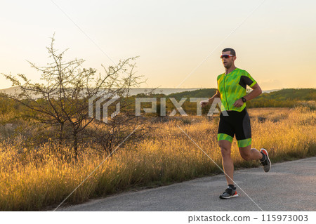 Triathlete in professional gear running early in the morning, preparing for a marathon, dedication to sport and readiness to take on the challenges of a marathon.  115973003