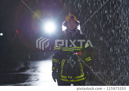 A determined female firefighter in a professional uniform striding through the dangerous, rainy night on a daring rescue mission, showcasing her unwavering bravery and commitment to saving lives. 115973203