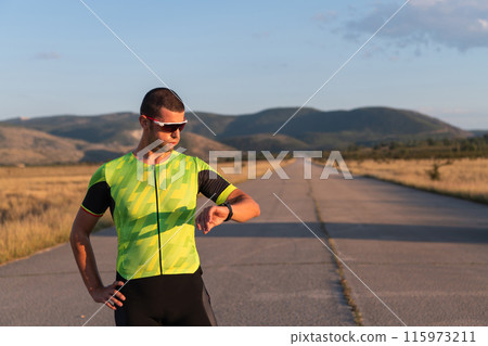 The triathlete checking his training statistics on a smartwatch, analyzing his performance and progress. With dedication, discipline, and perseverance, he strives to improve his physical abilities and The triathlete checking his training statistics on a smartwatch, analyzing his performance and progress. With dedication, discipline, and perseverance, he strives to improve his physical abilities and 115973211