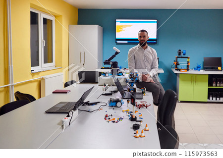 A bearded man in a modern robotics laboratory, immersed in research and surrounded by advanced technology and equipment. 115973563
