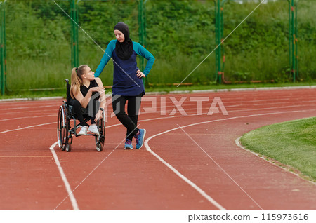 A Muslim woman wearing a burqa resting with a woman with disability after a hard training session on the marathon course 115973616