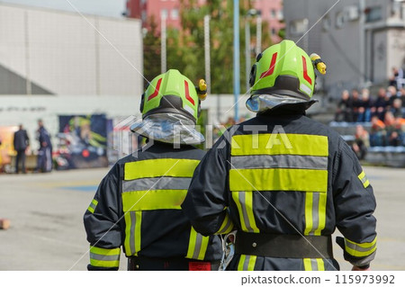 A team of confident and accomplished firefighters strides purposefully in their uniforms, exuding pride and satisfaction after successfully completing a challenging firefighting mission A team of confident and accomplished firefighters strides purposefully in their uniforms, exuding pride and satisfaction after successfully completing a challenging firefighting mission 115973992