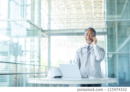 Senior man wearing work clothes, smartphone 115974332