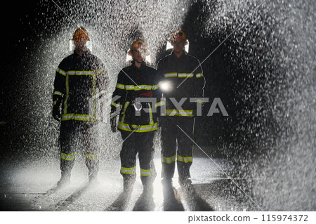 A group of professional firefighters marching through the rainy night on a rescue mission, their determined strides and fearless expressions reflecting their unwavering bravery and unwavering A group of professional firefighters marching through the rainy night on a rescue mission, their determined strides and fearless expressions reflecting their unwavering bravery and unwavering 115974372