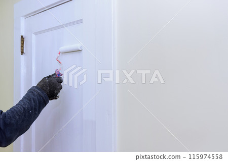 Doors are painted with white paint with roller during repairs 115974558