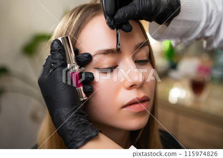 Artist carefully selects Strong lifting formula for eyebrows. Cosmetic professional ensures thorough coverage of brow with cosmetic Artist carefully selects Strong lifting formula for eyebrows. Cosmetic professional ensures thorough coverage of brow with cosmetic 115974826