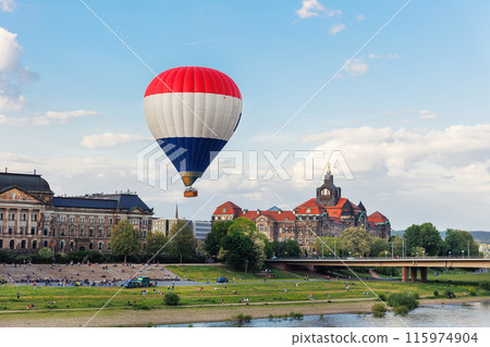 Hot air balloon with people tourist flying over Elbe river in Dresden Saxony State Chancellery Ministry of Finance background. Travel city tour trip flight Saxony capital city sightseeing landmark 115974904