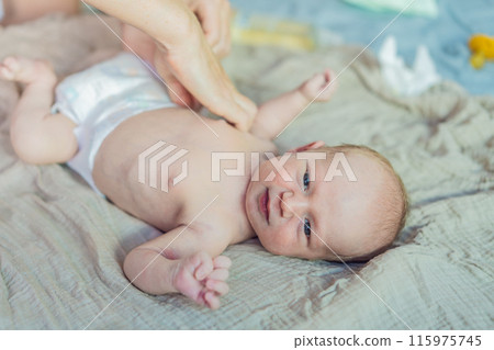 The newborn's skin is peeling. Mom uses skin products and massages to care for and soothe the baby's delicate skin, ensuring comfort and promoting healthy skin 115975745
