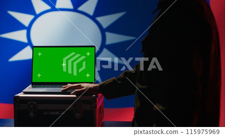 Taiwan specials ops unit uses green screen laptop to counteract Chinese propaganda promoting CCP One China policy. Taiwanese insurgent advocates for independence online using mockup notebook, camera A 115975969