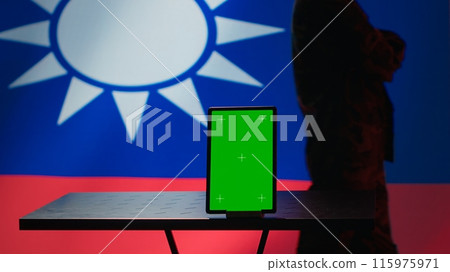 Taiwan military unit patrolling in command room, devising strategies to combat Chinese invasion, isolated screen tablet. Taiwanese insurgent walks in control center in front of mockup device, camera A 115975971