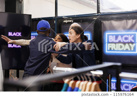 Black Friday crowd control. Anxious frenzied people shoppers near the store entrance during seasonal sales, waiting to start shopping in clothing store and get best deals first Black Friday crowd control. Anxious frenzied people shoppers near the store entrance during seasonal sales, waiting to start shopping in clothing store and get best deals first 115976164