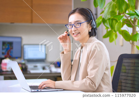 一位戴著耳機在辦公室工作的中年婦女 115977020