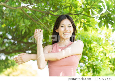 Woman doing yoga in green park (outdoor portrait, relaxing) 115977350