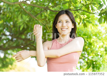 Woman doing yoga in green park (outdoor portrait, relaxing) 115977352