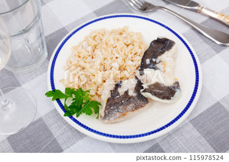 Tender meat of baked cod fillet is garnished with boiled basmati rice. Tender meat of baked cod fillet is garnished with boiled basmati rice. 115978524