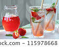 Summer refreshing homemade cocktail with strawberries and mint on the table in a bright summer kitchen in the garden 115978668