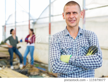 Man in a greenhouse Man in a greenhouse 115979077