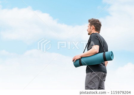 穿著運動服的白人男子在藍天下帶著瑜珈墊行走 115979204