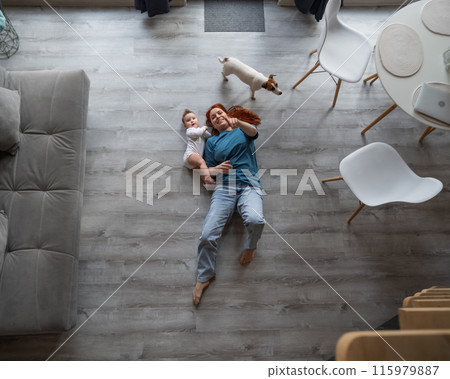 Top view of caucasian woman lying on floor with son and jack russell terrier dog.  115979887