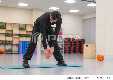 Caucasian man doing warm-up before exercise at a climbing wall. Caucasian man doing warm-up before exercise at a climbing wall. 115980034