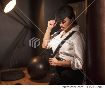 Caucasian woman in a men's suit in the style of Peaky Blinders. Caucasian woman in a men's suit in the style of Peaky Blinders. 115980201