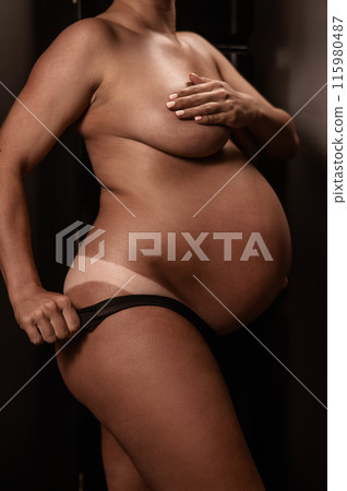 Pregnant woman pulls back her panties showing instant tan. Vertical photo. Pregnant woman pulls back her panties showing instant tan. Vertical photo. 115980487