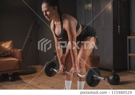 Caucasian woman doing deadlifts in retro gym. Caucasian woman doing deadlifts in retro gym. 115980529
