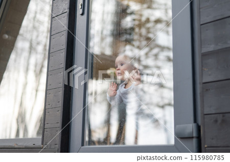 Baby boy standing by the patio window.  115980785