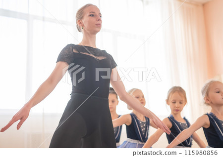 Children's ballet school. Caucasian woman teaching ballet to little girls.  115980856