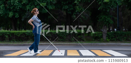 Blind pregnant woman crosses the road at a crosswalk with a cane.  115980913